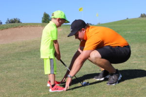 Junior Golfer being taught proper stance by Golf Instructor