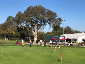 Golf instructor teaching putting clinic on green